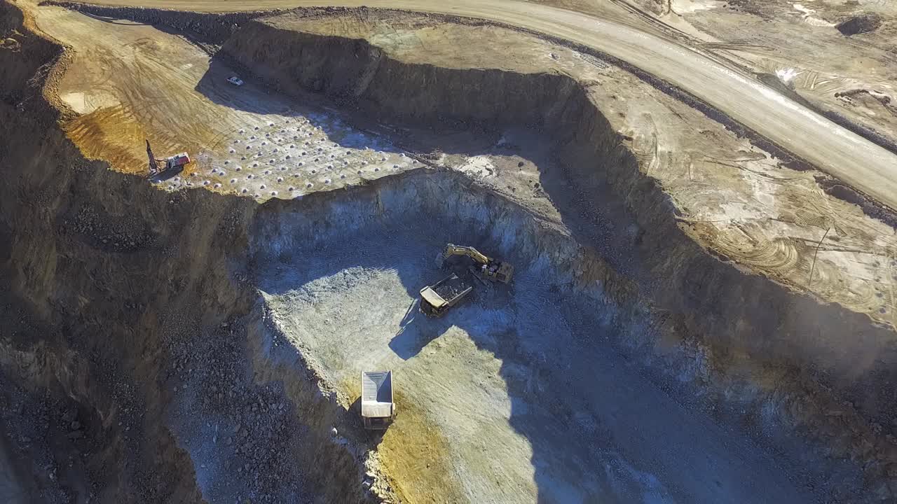Heavy machinery working in te riotinto open pit copper mine aerial shot