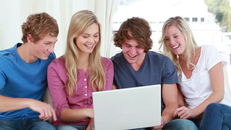 Happy-friends-laughing-in-front-of-a-laptop