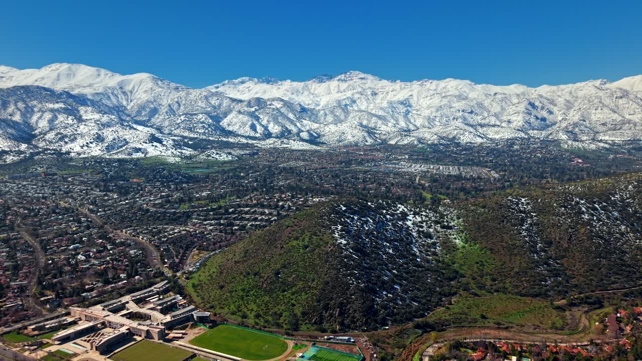 Santiago Nevado cityscape stretches below massive snow-covered mountains in the distance