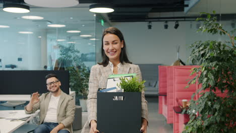 woman leaving the office with box of belongings