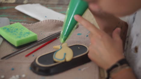 imágenes de una mujer caucásica haciendo y glaseando galletas de ballena