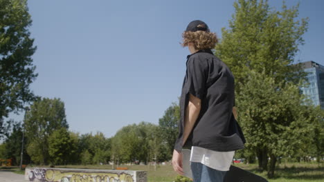 caucasian boy walking in skatepark.