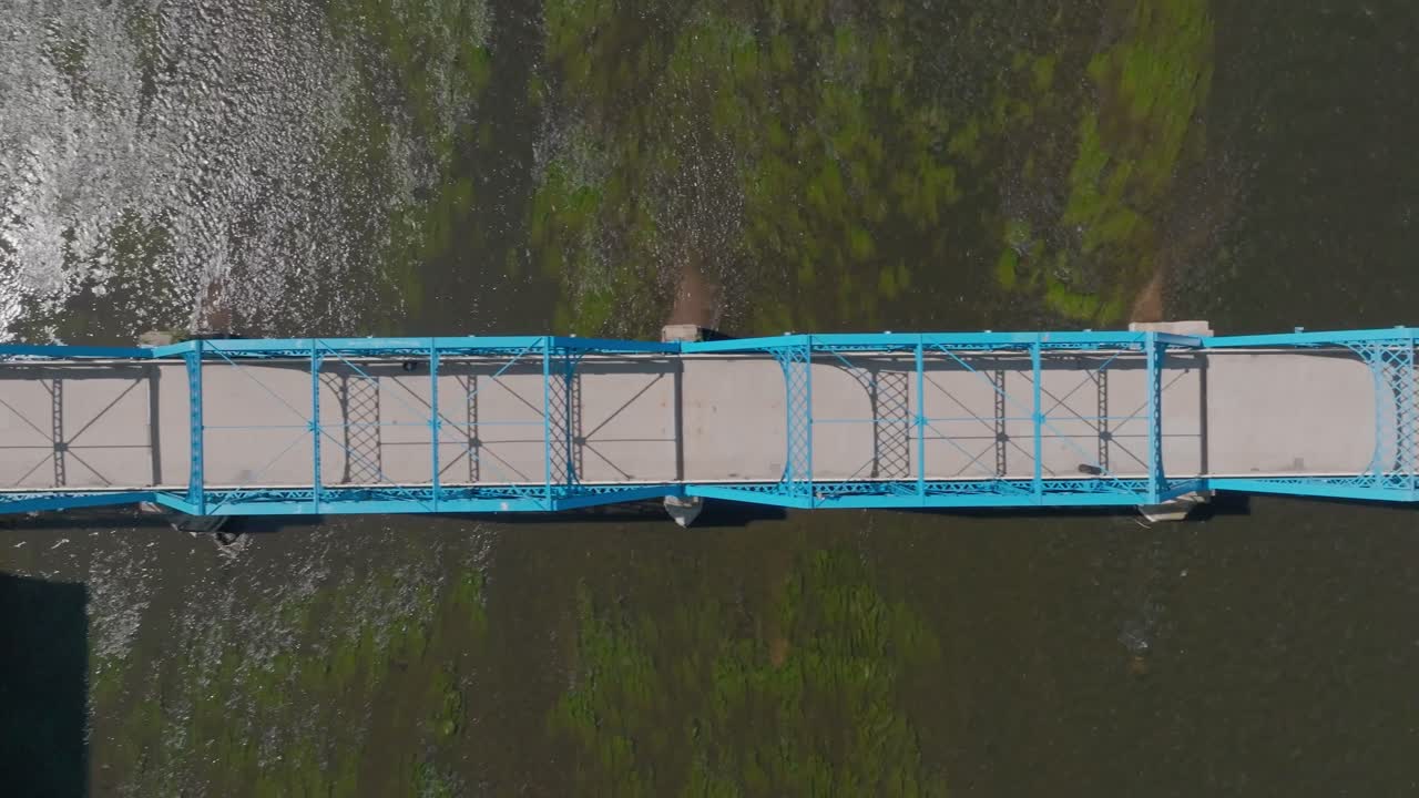 puente azul sobre el río grand en el centro de grand rapids, michigan con video de avión no tripulado por encima moviéndose de derecha a izquierda