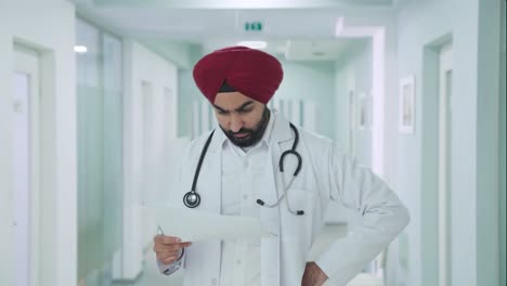 Estresado-Médico-Indio-Sikh-Comprobando-Informes-Médicos.