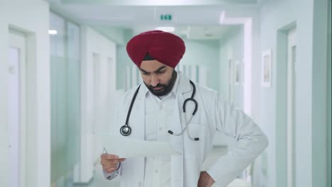 stressed sikh indian doctor checking medical reports