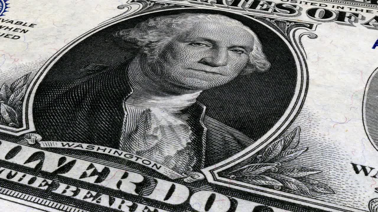Én dollar og krøllet portrett av George Washington på en amerikansk pengeseddel
