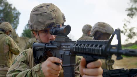 Vista-Trasera-De-Soldados-Militares-De-Raza-Mixta-Entrenando-Con-Rifles-En-Campos-Durante-El-Entrenamiento-Militar-4k