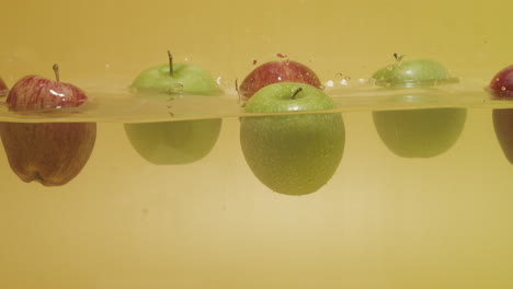 foto de un montón de manzanas con diferentes colores flotando en el agua
