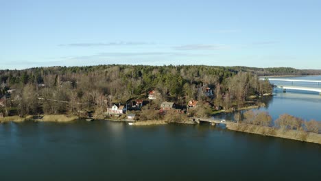 Friedliche,-Charmante-Schwedische-Siedlung-Ekolsund,-Schweden-Im-Einklang-Mit-Der-Natur-An-Den-Ufern-Des-Flusses-Mit-Autobahnbrücken-Im-Hintergrund