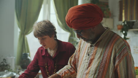 woman assisting indian chef cooking puris in kitchen during culinary show