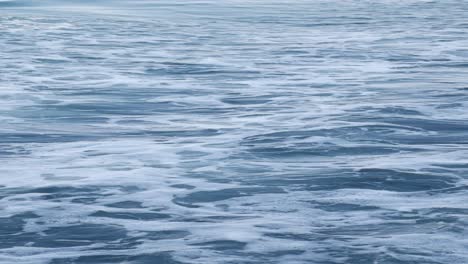 blue ocean water with white foam