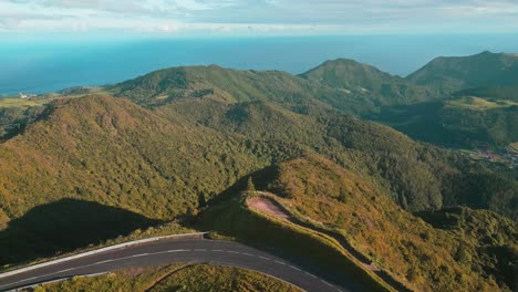 aerial panorama over mountain road on top of forested hills in sao miguel island, azores