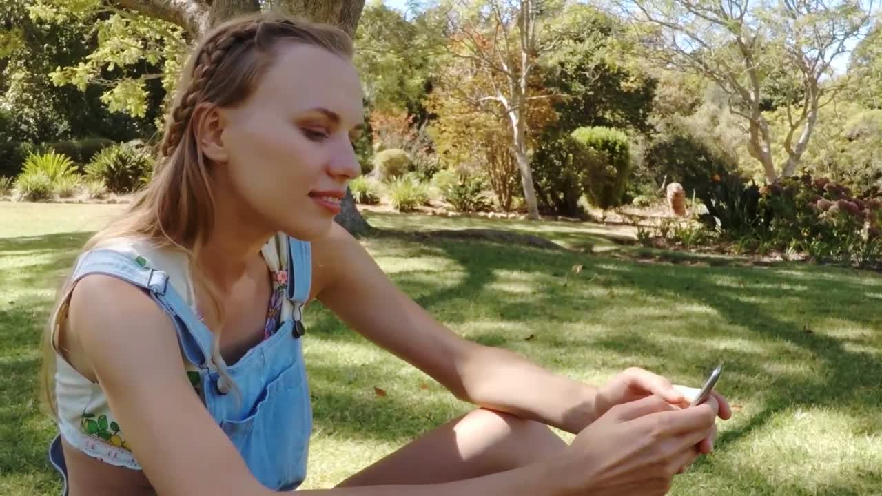 공원에서 문자를 보내는 예쁜 소녀