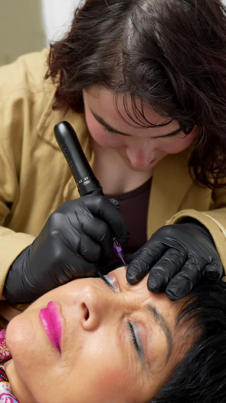Beautician Applying Permanent Makeup to Woman's Eyebrows
