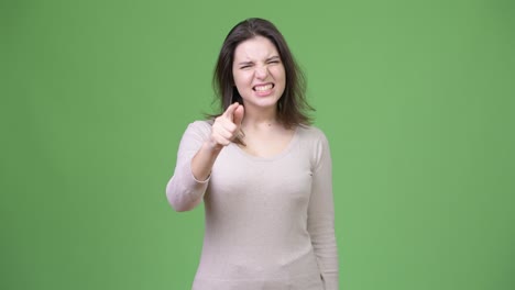 카메라를 가리키며 말하는 젊은 화를 내는 아름다운 여자