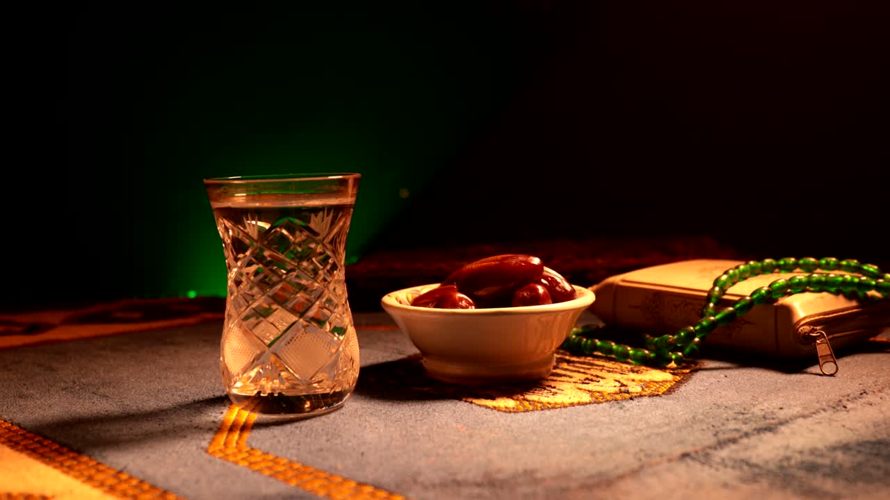 agua y dátiles. el iftar es la comida de la noche. vista deslizante de la decoración vacaciones de ramadán kareem. tarjeta de felicitación festiva, invitación para el mes sagrado musulmán ramadán kareem. fondo oscuro. enfoque selectivo