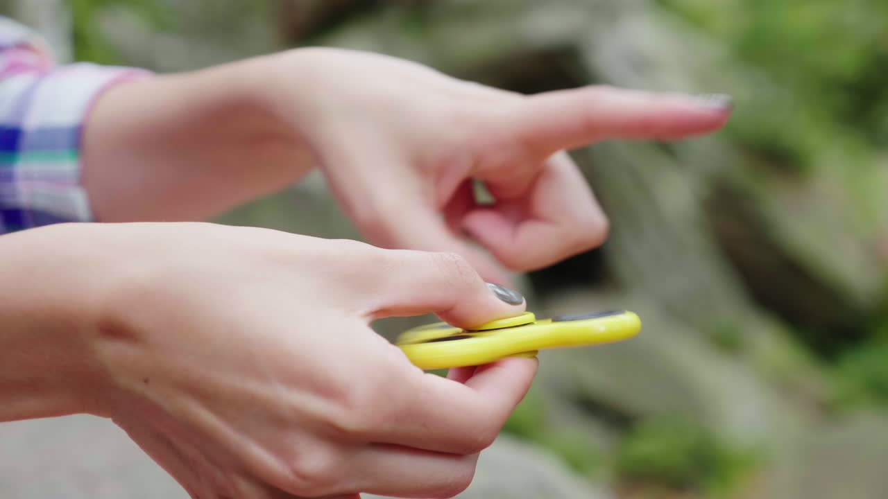 필드 4k 비디오의 얕은 깊이로 회전하는 장난감 비디오를 가지고 노는 여성 손