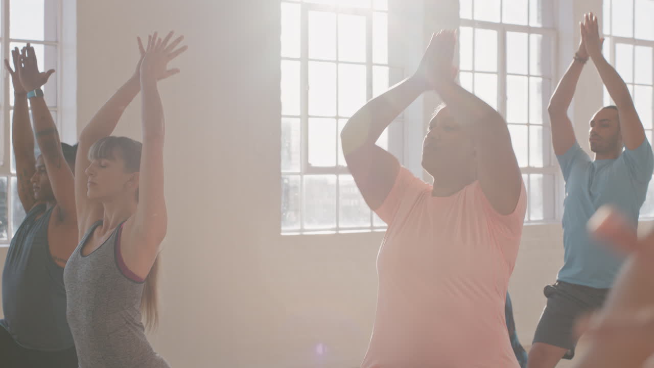 clase de yoga mujer joven con sobrepeso ejercitando un estilo de vida saludable practicando pose de guerrero disfrutando de entrenamiento físico para perder peso en el estudio al amanecer
