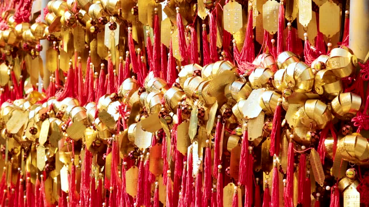 Close-up view of golden bells adorned with vivid red ribbons, creating a striking visual display.