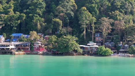 drone perspective of white sand beach budget accommodation on koh chang with beach huts and bungalows sunny morning, thailand's coastal beauty