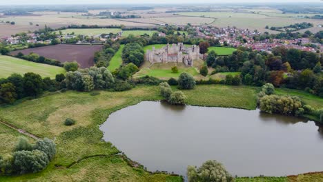 aerial: framlingham castle with lake and agricultural land at suffolk, england - drone flying backward shot