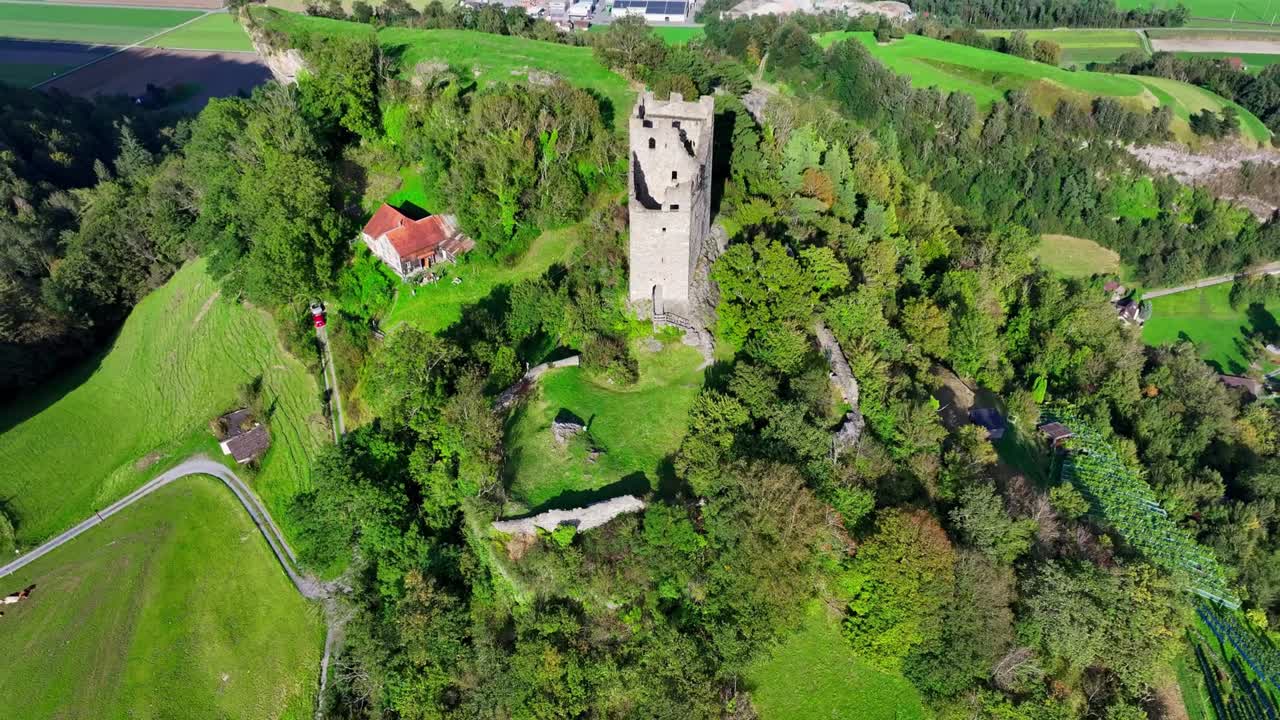 Volo cinematografico con drone sulle rovine del castello di Wartau vicino a Sargans, con strutture medievali ben conservate e le vicine fortificazioni del Ridotto Svizzero della Seconda Guerra Mondiale.