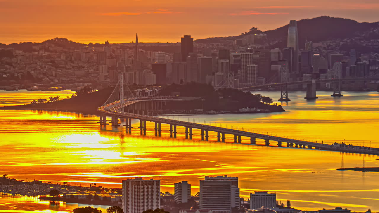 San Francisco skyline and glowing Oakland Bay Bridge during twilight Time-lapse