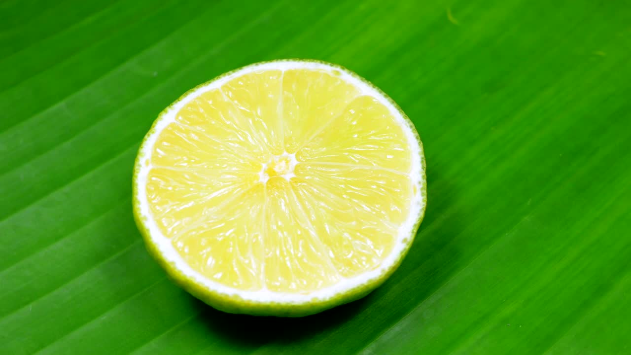 una rebanada de limón verde está girando lentamente en el estudio con los detalles.