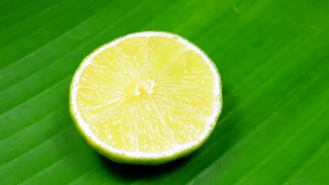una rebanada de limón verde está girando lentamente en el estudio con los detalles.