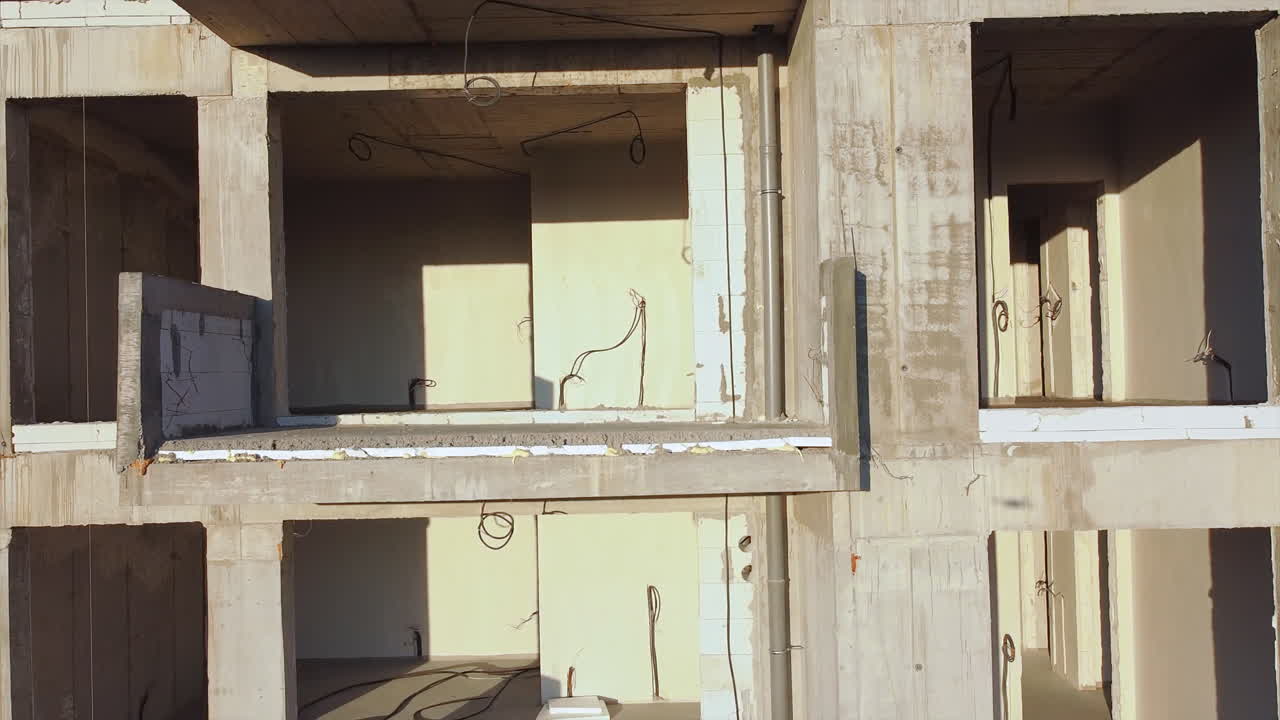 Construction works of a building with scaffolding on the facade. View from the drone. Bucharest, Romania