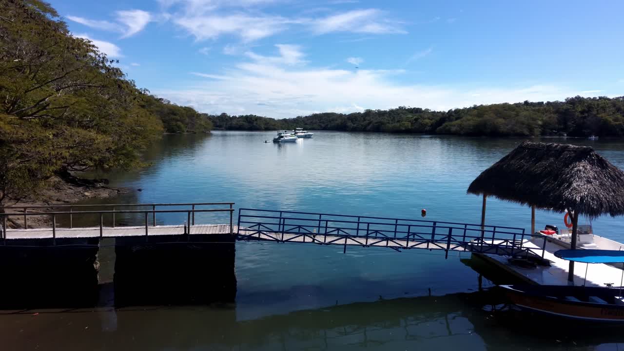 sobrevuelo aéreo de drones barcos pacíficos en el río con muelle en el paisaje de la jungla, 4k