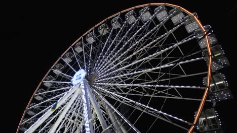 vista nocturna en una gran rueda gigante con una hermosa iluminación. rueda gigante de invierno girando en un parque de atracciones. video de resolución 4k