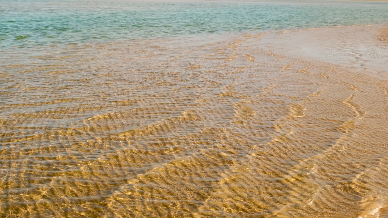 Clear Water Rippling Over Sandy Beach