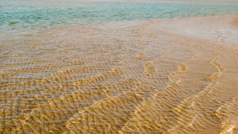 clear water rippling over sandy beach