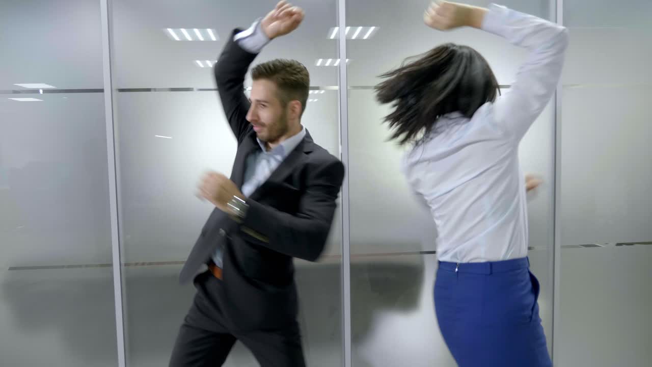 Business Colleagues Dancing in Office Corridor
