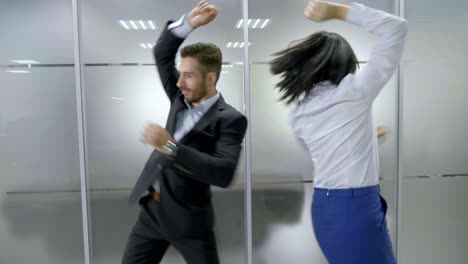 business colleagues dancing in office corridor