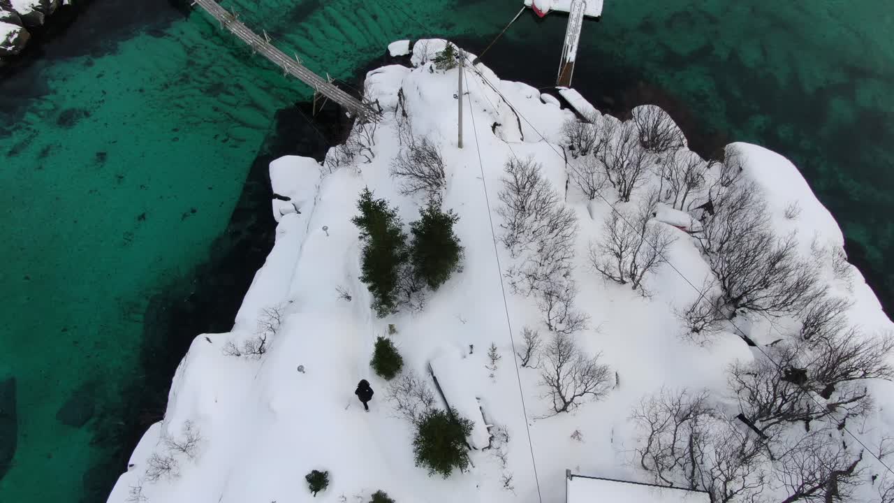 노르웨이의 섬을 둘러싸고 있는 투르코이즈색의 투명한 바다를 보여주는 겨울의 트롬소 지역의 드론 뷰