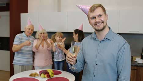 a family celebrates a birthday with champagne and cake.