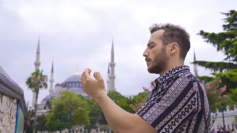 young man praying in historical mosque.