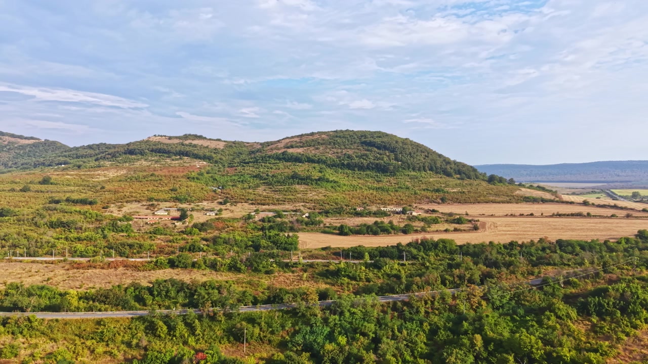 Veduta panoramica di verdi colline e campi sotto un cielo azzurro durante il giorno in campagna