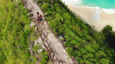 tourist walking, without a t-shirt, down from the top of an active vulcano during a hot day