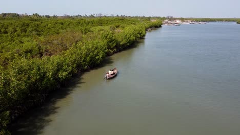 Vista-Panorámica-Aérea-De-Canoa-Navegando-Por-El-Río-Gambia-Con-Turistas,-Paisaje-Natural-De-áfrica-Occidental,-Destino-Turístico