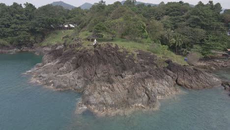 Tiro-De-órbita-Derecha-De-Drones,-Vista-De-Pájaro-De-La-Costa-De-Roca-De-Granito-En-Una-Isla-Tropical-Con-Selva-Exuberante-Bosque-Verde-Y-Océano