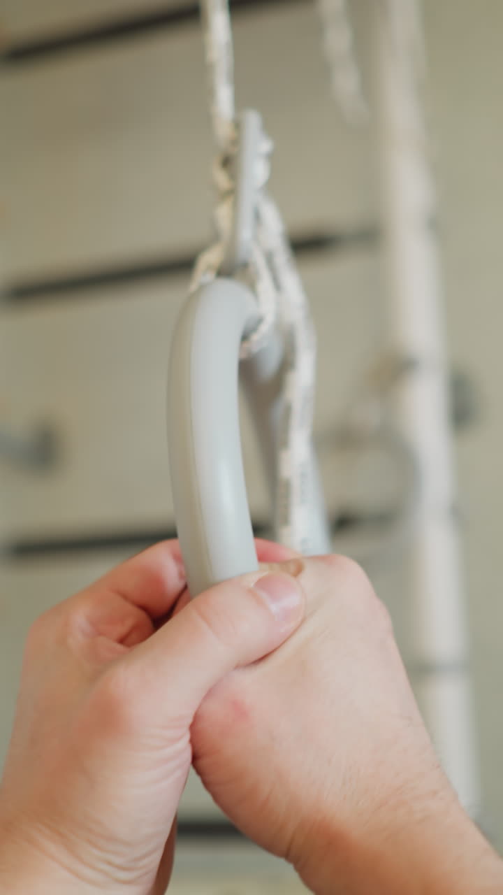 스포츠 벽에 체조 링을 잡고 따뜻해지는 사람의 1인칭 시각, 손과 링 초점