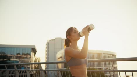 Ein-Glückliches-Mädchen-In-Einer-Sportlichen-Sommeruniform-Trinkt-Morgens-Wasser-Aus-Einer-Speziellen-Sportflasche