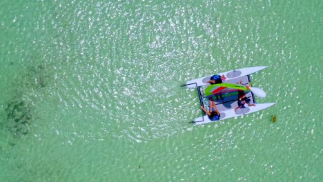 Small-sailing-catamaran-on-transparent-waters-of-Juanillo-beach,-Dominican-Republic