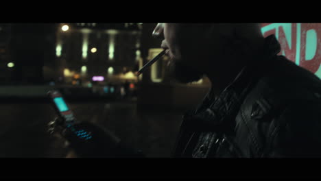 a bald dangerous looking man smoke outside a train station