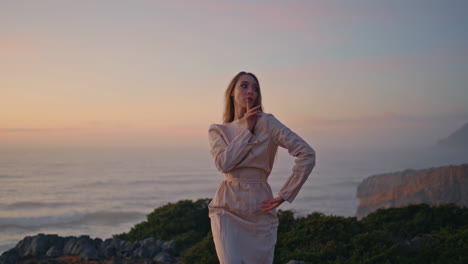 niña tierna bailando al atardecer acantilado doblando cuerpo flexible de cerca. mujer actuando
