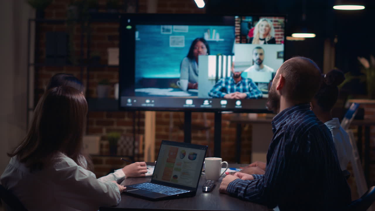 Employees discussing presentation with team in videocall, slow motion