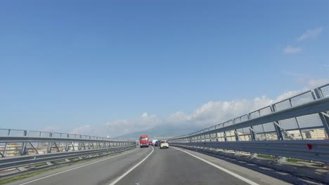 driving on a narrow and busy highway with extended guard rails high above the city in europe